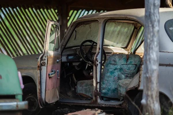 Старый ржавый заброшенный автомобиль с открытыми дверями — стоковое фото