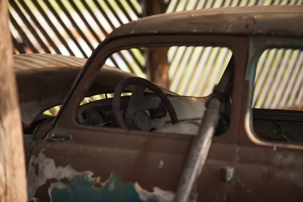 Um velho carro abandonado completamente enferrujado — Fotografia de Stock