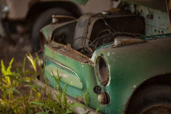 Une vieille voiture verte rouillée. sans phares et capot — Photo