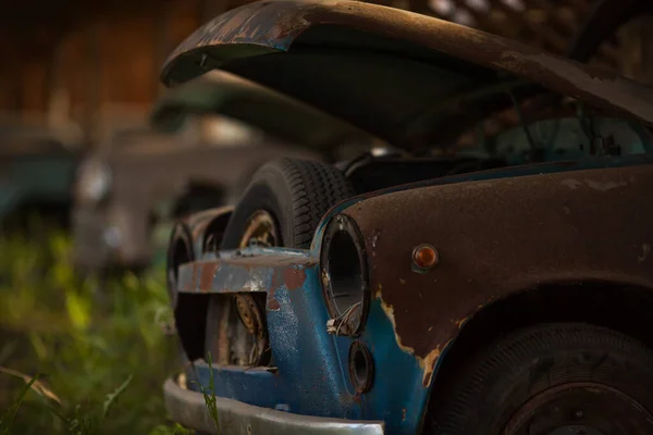 Um velho carro abandonado enferrujado com um capuz aberto Imagens De Bancos De Imagens