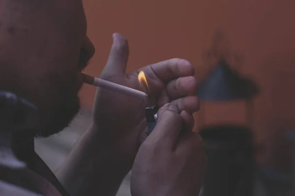 A man lights a cigarette in the evening — Stock Photo, Image