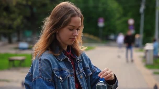 Dziewczyna pije wodę z butelki na ulicy — Wideo stockowe