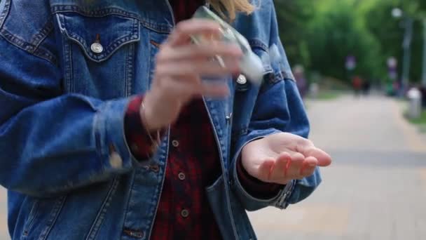 Chica utiliza antiséptico en la calle en el Parque . — Vídeos de Stock
