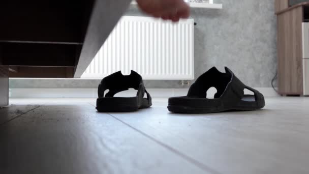 Homme met sur noir tongs et feuilles — Video