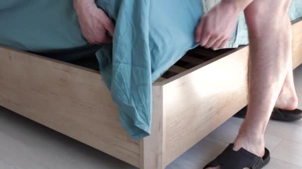 Mężczyzna robi prześcieradło w łóżku — Wideo stockowe