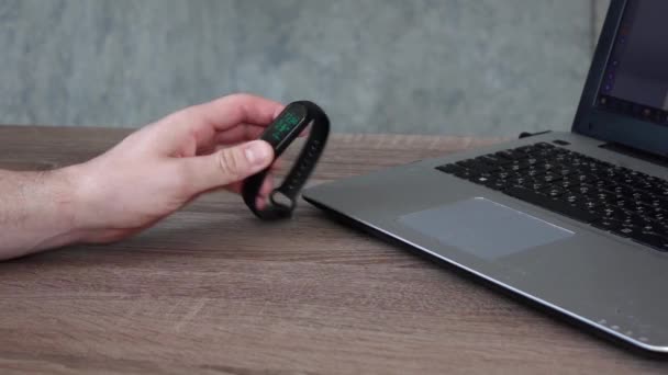 Un homme assis à une table met une montre de sport Russie Stary Oskol, 2 mai 2020 — Video