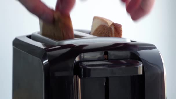 El hombre toma el pan y lo pone en la tostadora — Vídeo de stock