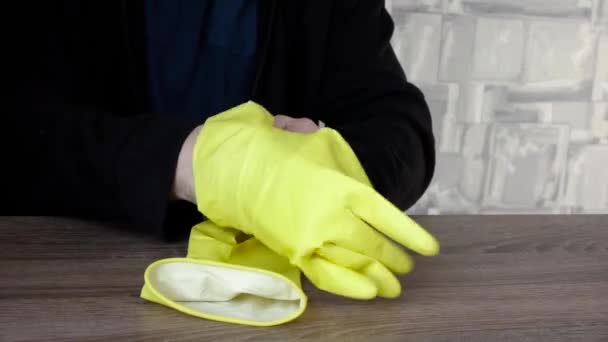 Zieht der Mann gelbe Handschuhe an. das Konzept der epidemischen Sicherheit — Stockvideo