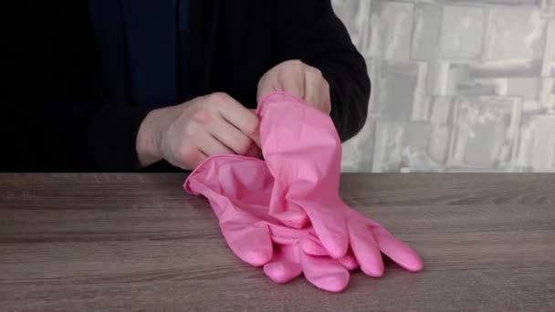 De man trekt roze handschoenen aan. het begrip "epidemische veiligheid" — Stockvideo