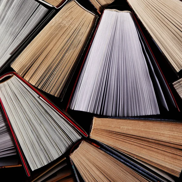 Książki. Wiele kolorowych, grubych książek stoi na ciemnym tle. — Zdjęcie stockowe