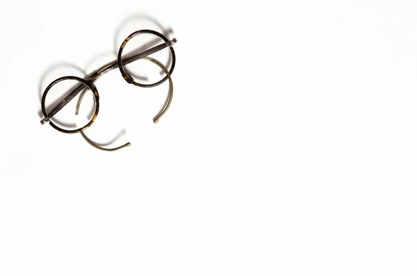 Round old eyeglasses for vision correction lie on a white background — 图库照片