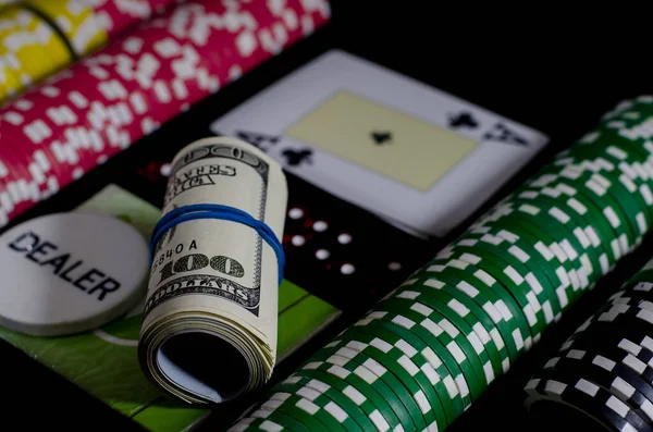 A 100 dollar kupurs is on the blackjack table next to poker chips and a dealer's chip — ストック写真