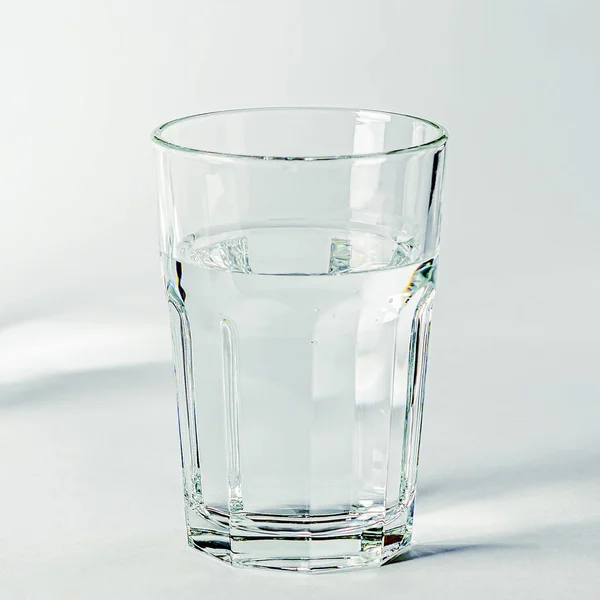 Reines klares Wasser in einem Glas- und Glaskrug steht auf weißem Hintergrund — Stockfoto