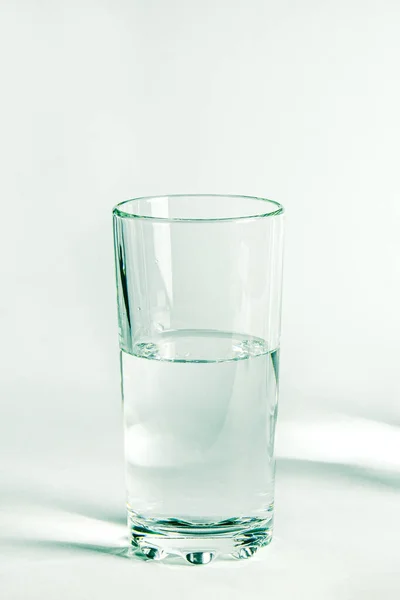 Reines klares Wasser in einem Glas- und Glaskrug steht auf weißem Hintergrund — Stockfoto