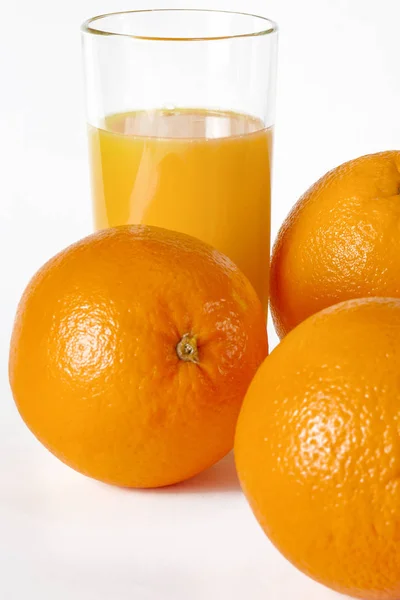 Vidro de suco de laranja fresco com frutas frescas no fundo branco — Fotografia de Stock