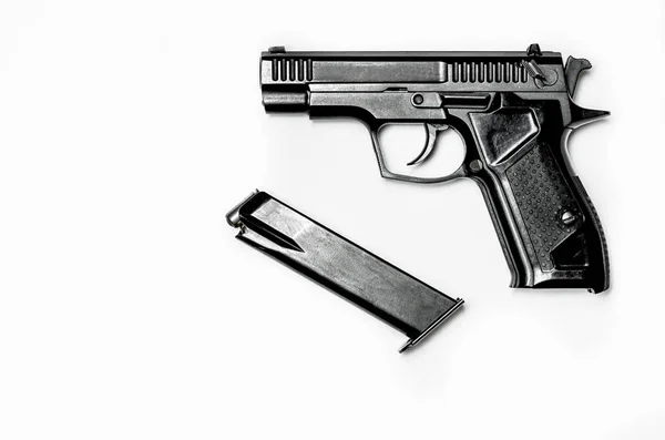 Uma pistola preta com uma revista para cartuchos está em um fundo branco — Fotografia de Stock