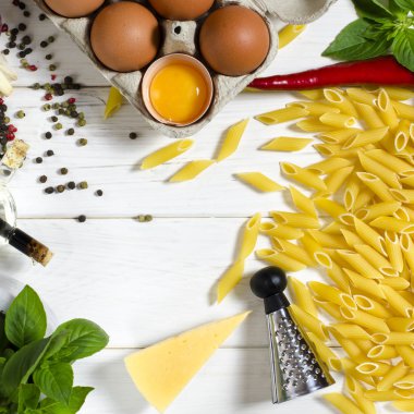 Penne makarna, Yeşil fesleğen, parmesan, susam, sarımsak, Chilli, yumurta beyaz bir ağaç masada yalan