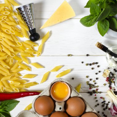 Penne makarna, Yeşil fesleğen, parmesan, susam, sarımsak, Chilli, yumurta beyaz bir ağaç masada yalan