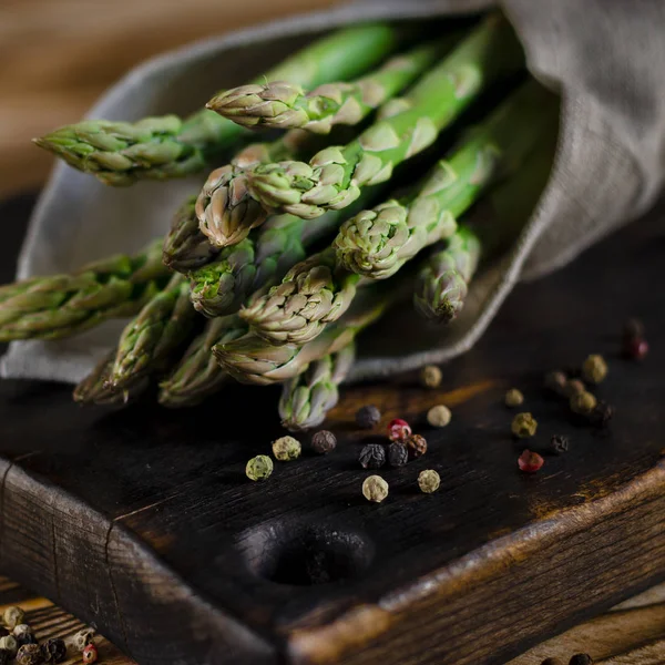 Зеленая диета для вегетарианцев: сочная зеленая спаржа лежит на деревянной доске — стоковое фото