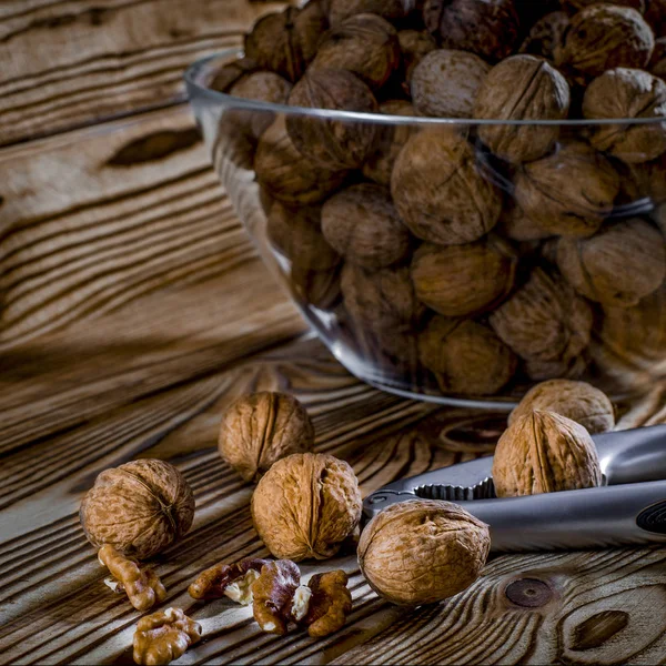 Alimenti sani: noci rotonde con noci si trovano su un tavolo di legno — Foto Stock