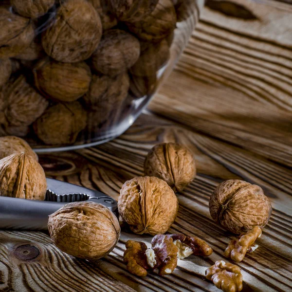 Alimenti sani: noci rotonde con noci si trovano su un tavolo di legno — Foto Stock