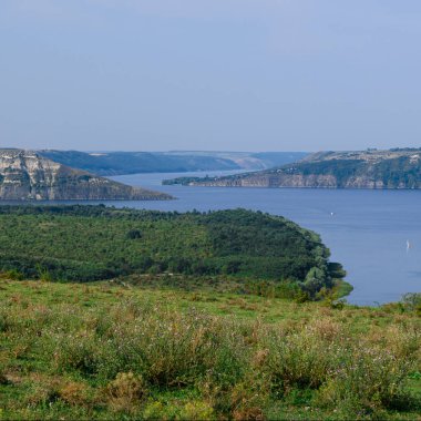 Dağların arasında eski yüksek ormanlarla kaplı büyük bir dağ gölü.