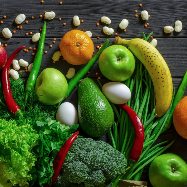 Raw healthy food, grocery set on a black wooden table