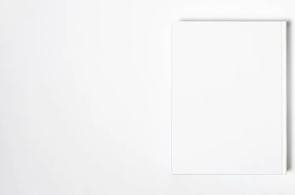 Макет закритої порожньої квадратної книги на фоні білого текстурованого паперу — стокове фото