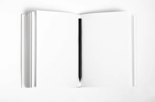 Макет закритої порожньої квадратної книги та чорного олівця на фоні білого текстурованого паперу — стокове фото