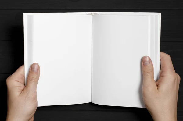 Las manos de los hombres sostienen un libro blanco con páginas limpias —  Fotos de Stock