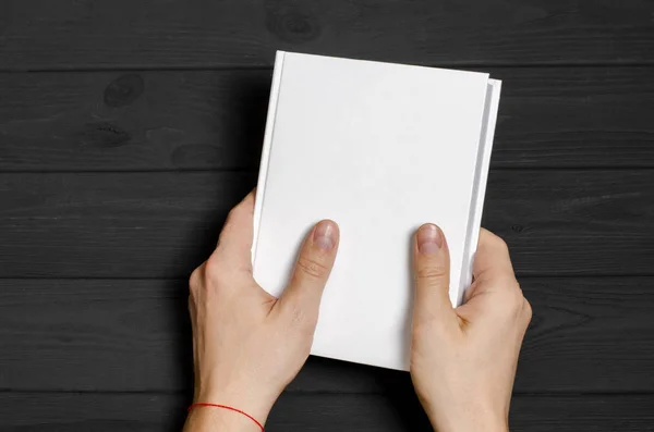 Men's hands holding closed book with blank cover on light background — Stok fotoğraf