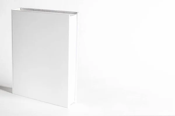 Макет закритої порожньої квадратної книги на фоні білого текстурованого паперу — стокове фото