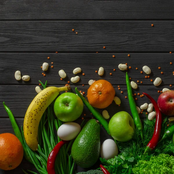 Raw healthy food, grocery set on a black wooden table