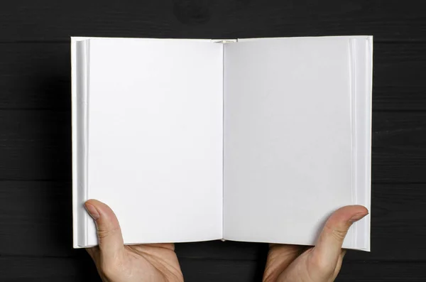 Las manos de los hombres sostienen un libro blanco con páginas limpias —  Fotos de Stock