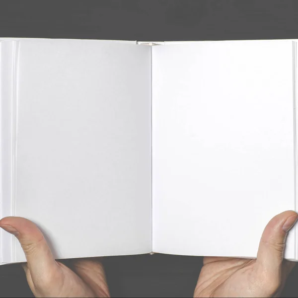 Las manos de los hombres sostienen un libro blanco con páginas limpias —  Fotos de Stock