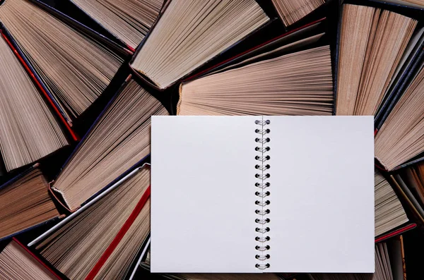 Sebuah buku catatan putih dengan halaman yang bersih terletak pada buku-buku berwarna tua — Stok Foto