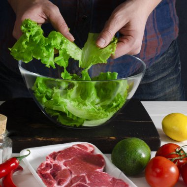 Adam marul, yeşil salata hazırlanıyor. Sağlıklı gıda kavramı