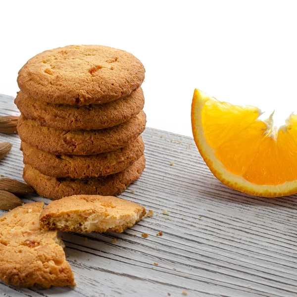 Круглые апельсиновые печенья с красочными засахаренными фруктами и ломтиком сочного апельсина, лежащего на деревянном столе — стоковое фото