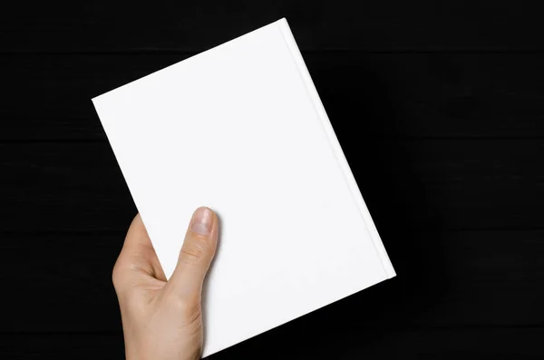 Men's hands holding closed book with blank cover on light background — Stok fotoğraf