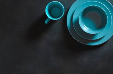 Multi-colored kitchen utensils of different shapes and sizes stand on a dark background