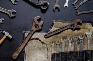 Evde tamir ve yeniden yapılandırma için kullanılan vintage araç kiti siyah bir arkaplanda yatar