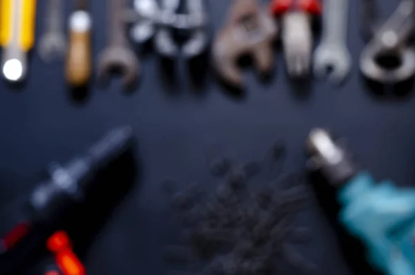 Blurred. Tools for repair and reconstruction in home conditions lie on a black background