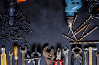 Ev koşullarında tamir ve yeniden yapılandırma için el aletleri siyah arka planda yatar. Boşluğu kopyala