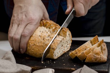 Ev yapımı hamur işleri. Erkek eli mutfakta ev yapımı allık ekmeği kesiyor.