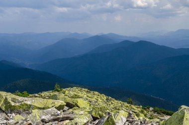 Sıradışı dağ yürüyüşleri. Sisteki yüksek sıradağların zeminine karşı yeşil oklarla kaplanmış devasa taşlar.