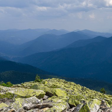 Sıradışı dağ yürüyüşleri. Sisteki yüksek sıradağların zeminine karşı yeşil oklarla kaplanmış devasa taşlar.