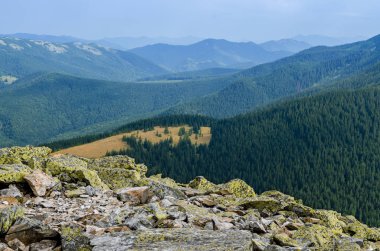 Sıradışı dağ yürüyüşleri. Sisteki yüksek sıradağların zeminine karşı yeşil oklarla kaplanmış devasa taşlar.