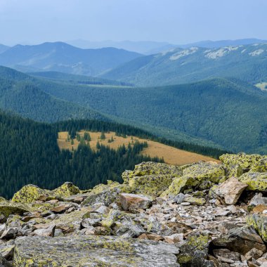 Sıradışı dağ yürüyüşleri. Sisteki yüksek sıradağların zeminine karşı yeşil oklarla kaplanmış devasa taşlar.