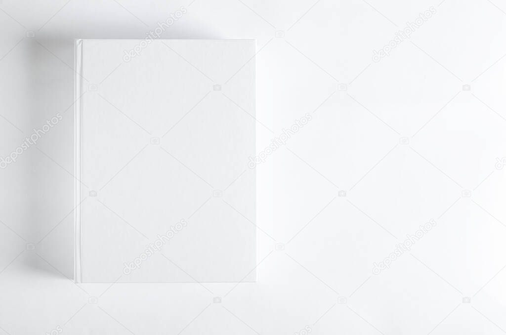 Mockup of closed blank square book at white textured paper background. Wall Background