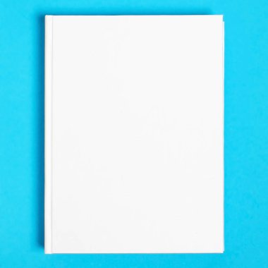 Beyaz desenli kağıt arkaplanda kapalı kare kitabın bir kopyası. Parlak mavi arkaplanda boş kare kapak şablonu
